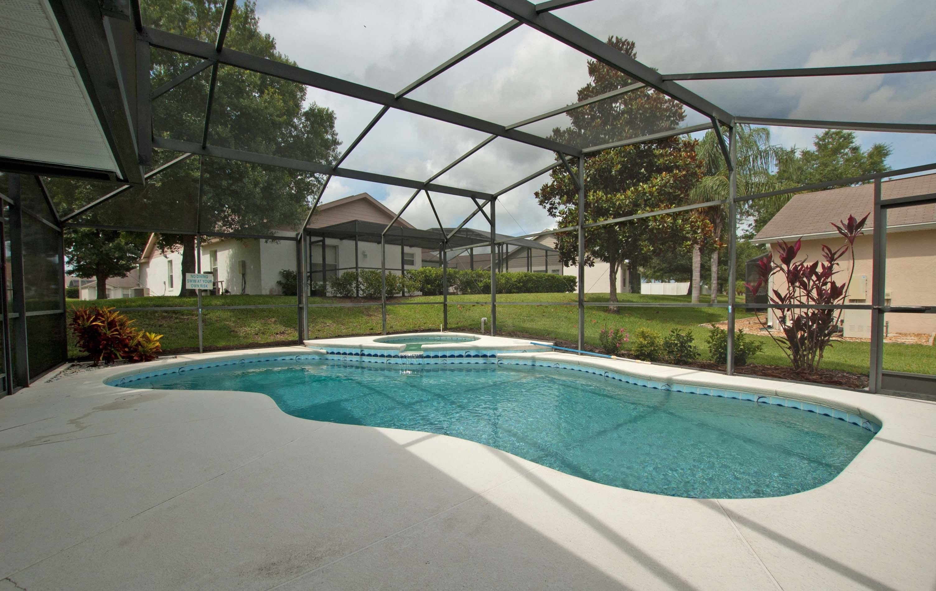A swimming pool with a covered area, surrounded by a residential neighborhood.