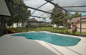 A swimming pool with a covered area, surrounded by a residential neighborhood. - Greater Groves-4 Bedrooms Home W/pool-5204GG Home by RedAwning (Clermont)