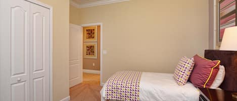 Quarto de hotel com duas camas, uma cômoda e uma porta.
