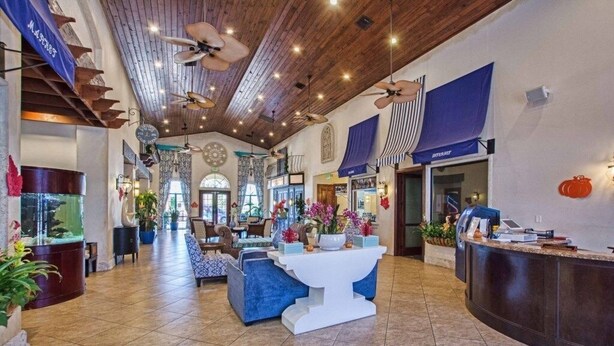 A spacious lobby with a high ceiling, wooden beams, and a reception desk.