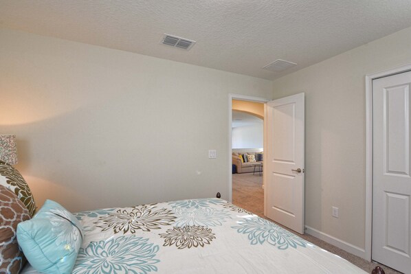 A bedroom with a bed, a door, and a hallway leading to another room. - Solterra - 5 Bedrooms House w/pool-7035SR Home by RedAwning (Davenport)