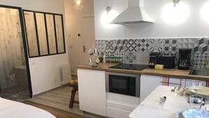 A compact kitchen with a microwave, coffee maker, and a small dining area with a table and chairs.