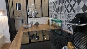 A kitchen with a wooden countertop, a coffee machine, and a spice rack.