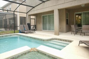 Una piscina interior con sillas de descanso y un patio cubierto.