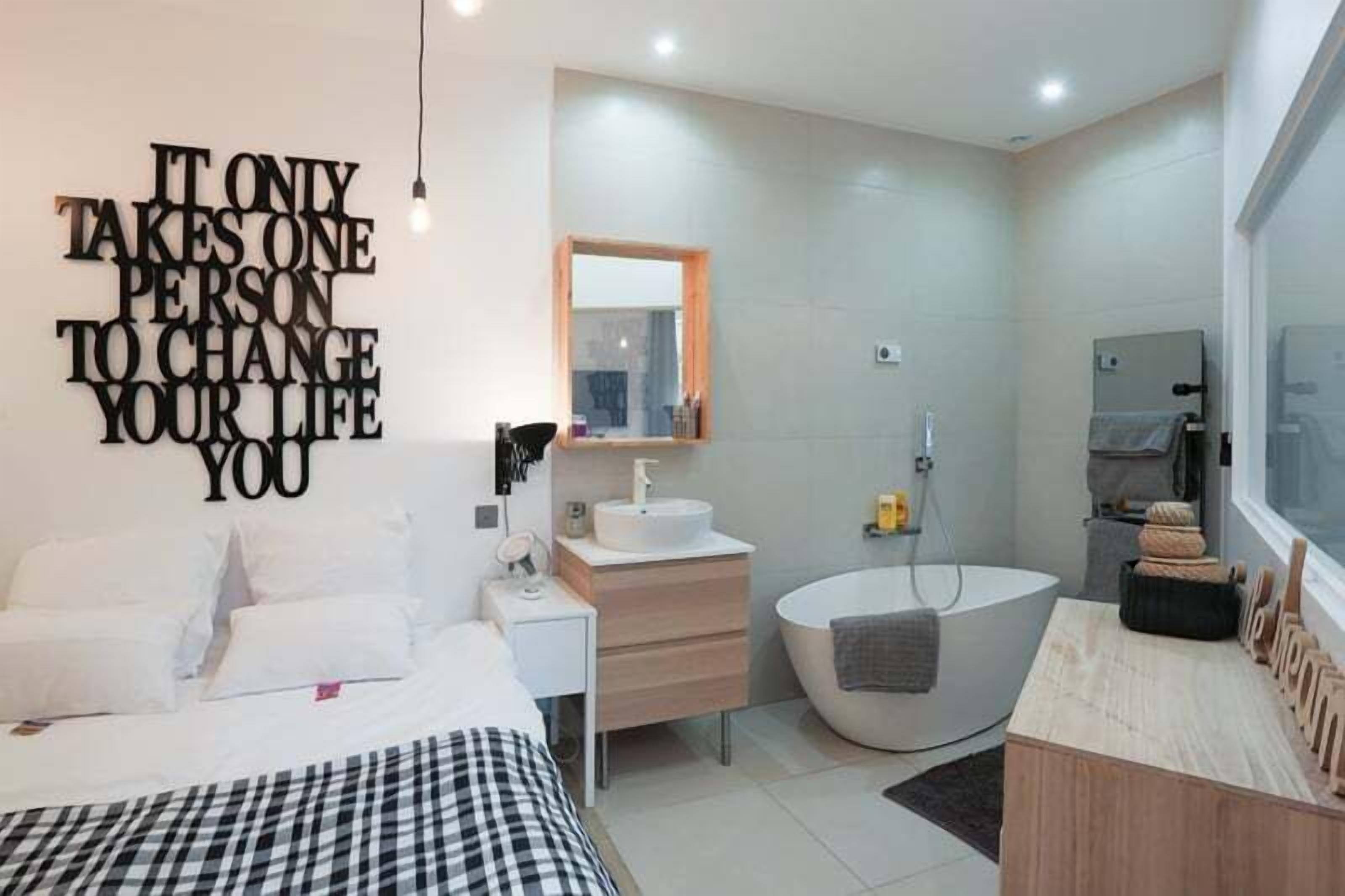 A modern bathroom with a bathtub, a sink, and a mirror.