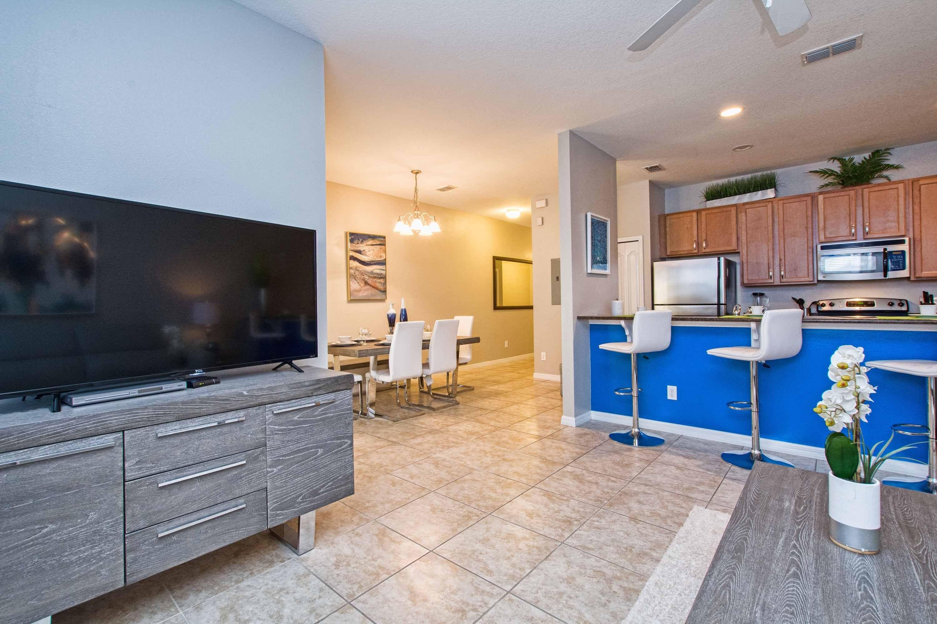 A modern kitchen with a blue countertop, stainless steel appliances, and wooden cabinets.