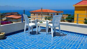 A terrace with blue tiled flooring, white plastic chairs, and a table with a book and a lantern. - Brand new Villa With Pool and Alcamo Marina Terrace (Alcamo)