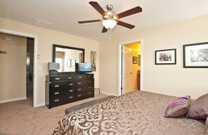 A bedroom with a bed, dresser, ceiling fan, and framed pictures on the wall. - Paradise Palms- 5 Bed Townhome W/splashpool-3024 5 Bedroom Townhouse by RedAwning (Kissimmee)