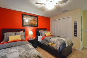 A bedroom with two beds, a ceiling fan, a nightstand with a lamp, and a framed picture on the wall. - Paradise Palms-4 Bed W/splashpool-3622pp 4 Bedroom Townhouse by RedAwning (Kissimmee)