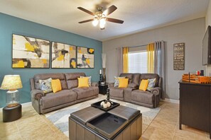 A living room with two brown sofas, a coffee table, and abstract art on the wall. - Paradise Palms-4 Bed W/splashpool-3622pp 4 Bedroom Townhouse by RedAwning (Kissimmee)