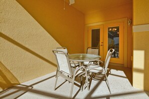 A dining area with a round table and four chairs, a textured wall, and a door with a window. - Paradise Palms- 4 Bed Townhome W/splashpool-3044pp 4 Bedroom Townhouse by RedAwning (Kissimmee)