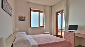 A bedroom with a bed, a desk, a chair, and a TV. - Belvedere Apt (Sorrento)