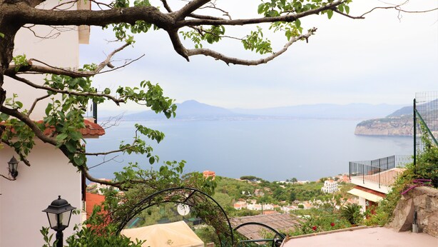 A coastal view with a balcony overlooking the sea, a stone wall, and a lamp post. - Belvedere Apt (Sorrento)