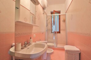 A bathroom with a sink, toilet, and shower area. - Belvedere Apt (Sorrento)