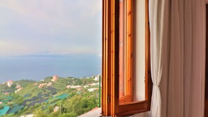 A window with a view of a coastal landscape, including houses and greenery. - Belvedere Apt (Sorrento)