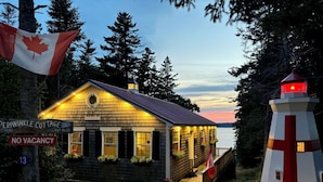 A wooden cottage with a sign indicating 'Periwinkle Cottage' and 'No Vacancy'. - Oceanfront cottage with new Oceanfront Master BR in 2023, complete remodel 2021 (Wilsons Beach)