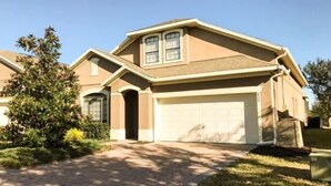 A residential house with a garage, a driveway, and a well-maintained lawn.