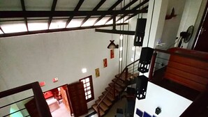 A spacious interior with a high ceiling, a staircase, and a seating area with a checkered cushion. - Luxury Villa Costanza (Hikkaduwa)