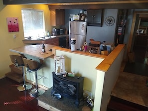 Una cocina compacta con estufa integrada, refrigerador y cafetera.