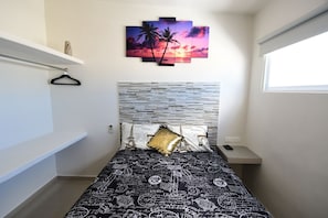 A bedroom with a bed, a nightstand, a wall-mounted painting, and a window. - B My Guest, Live Your Best Experience (Cancun)