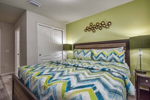 A bedroom with a bed, a door, a wall-mounted light fixture, and a nightstand. - Windsor-5 Bed W/splashpool-3801ww 5 Bedroom Townhouse by RedAwning (Kissimmee)