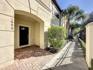 A building entrance with a black door, a brick pathway, and a small bush. - Windsor-5 Bed W/splashpool-3801ww 5 Bedroom Townhouse by RedAwning (Kissimmee)
