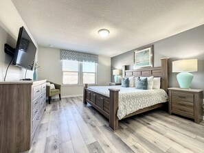 A bedroom with a bed, dresser, TV, and a window with blinds. - Windsor-5 Bed W/splashpool-3801ww 5 Bedroom Townhouse by RedAwning (Kissimmee)