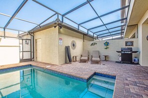 An indoor swimming pool with a glass ceiling, a barbecue grill, and a sign warning of hot water. - Windsor-5 Bed W/splashpool-3801ww 5 Bedroom Townhouse by RedAwning (Kissimmee)