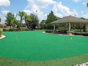 Un campo de golf con pabellón, césped verde y árboles.