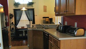 A compact kitchen with wooden cabinets, a sink, and a toaster. - Prime Location In Secure Safe 247 Manned Gatehouse Community With Clubhouse (Kissimmee)