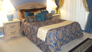 A bedroom with a bed, nightstands, and lamps. There are pictures on the wall and curtains on the window. - Prime Location In Secure Safe 247 Manned Gatehouse Community With Clubhouse (Kissimmee)