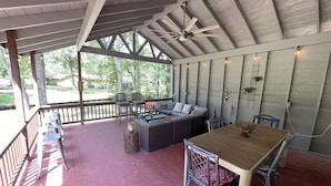 A covered outdoor patio with a wooden table and chairs, a sofa, and a ceiling fan. - !!!Private Lake!!! Fishing, Swimming & MORE!!! Charming Lakeside Bungalow!! (Conroe)
