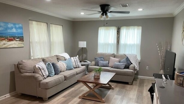 A living room with two sofas, a coffee table, and a ceiling fan. - !!!Private Lake!!! Fishing, Swimming & MORE!!! Charming Lakeside Bungalow!! (Conroe)