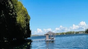 A tennis court with a gazebo in the background. - !!!Private Lake!!! Fishing, Swimming & MORE!!! Charming Lakeside Bungalow!! (Conroe)