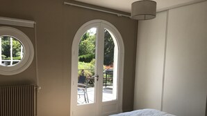 A bedroom with a large bed, a window, and a radiator.