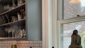 Una encimera de cocina con varios objetos, como botellas, vasos y frutas cítricas.