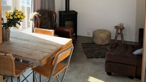 Una sala de estar acogedora con chimenea, muebles de madera y una araña.