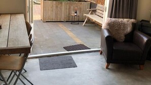 Un espacio de estar tipo loft con una mesa de madera, un sofá y una mesita con una botella.