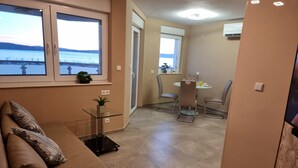 Un salon moderne comprenant un canapé, une table basse en verre et un coin repas avec une table et des chaises.