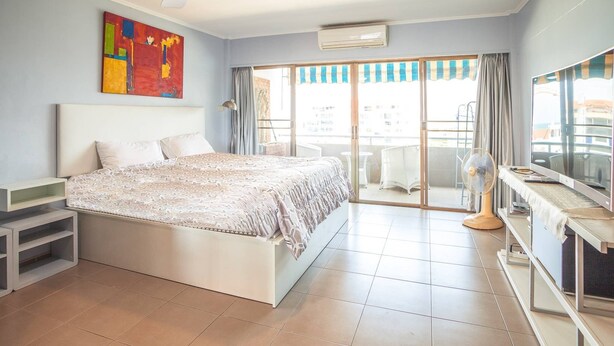 A bedroom with a bed, a ceiling fan, a TV, and a balcony with a view. - 1 Bedroom 716 High Floor Seaview (Pattaya)