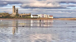 A beach with a historic building in the background.