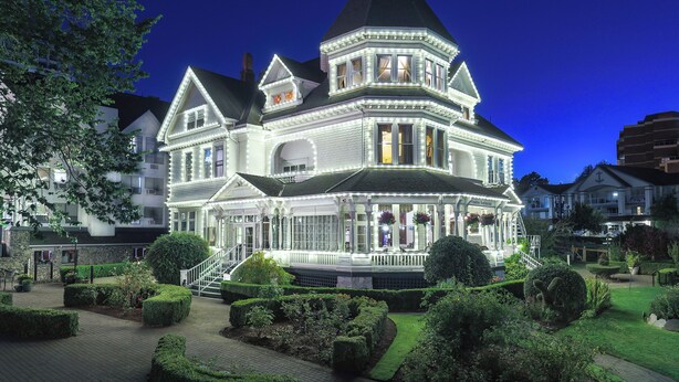 A large, ornate Victorian-style building with multiple stories, a prominent turret, and a well-maintained garden. - Pendray Inn & Tea House (Victoria)