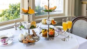 A three-tiered dessert stand with various pastries and a fruit slice on the top tier. - Pendray Inn & Tea House (Victoria)