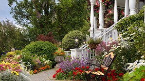 A garden pathway with a bench, surrounded by various flowers and greenery. - Pendray Inn & Tea House (Victoria)