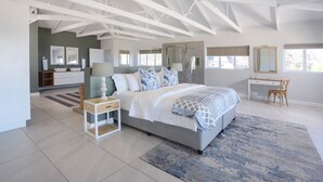 Un dormitorio moderno con una cama grande, un escritorio y una ducha.