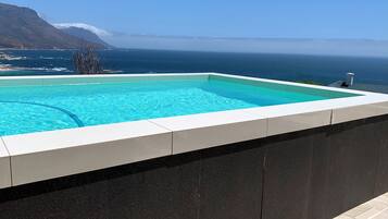 Een buitenzwembad, parasols voor strand/zwembad