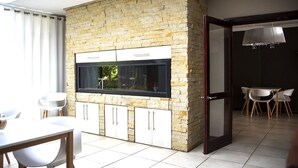 A modern kitchen with a stone backsplash, built-in cabinets, and a large window. - Kroon Manor (Moqhaka)