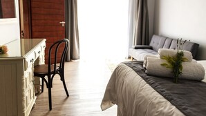 A bedroom with a bed, a dresser, a chair, and a window with curtains. - Kroon Manor (Moqhaka)
