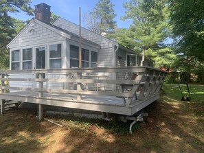 A house with a covered deck, a chimney, and a garage.
