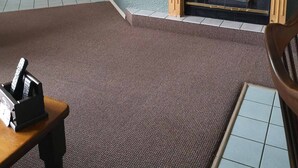 A living room with a fireplace, a television mounted on the wall, and a bed in the adjacent room. - Kelowna Timeshare July Rental for 1 Week (Kelowna)